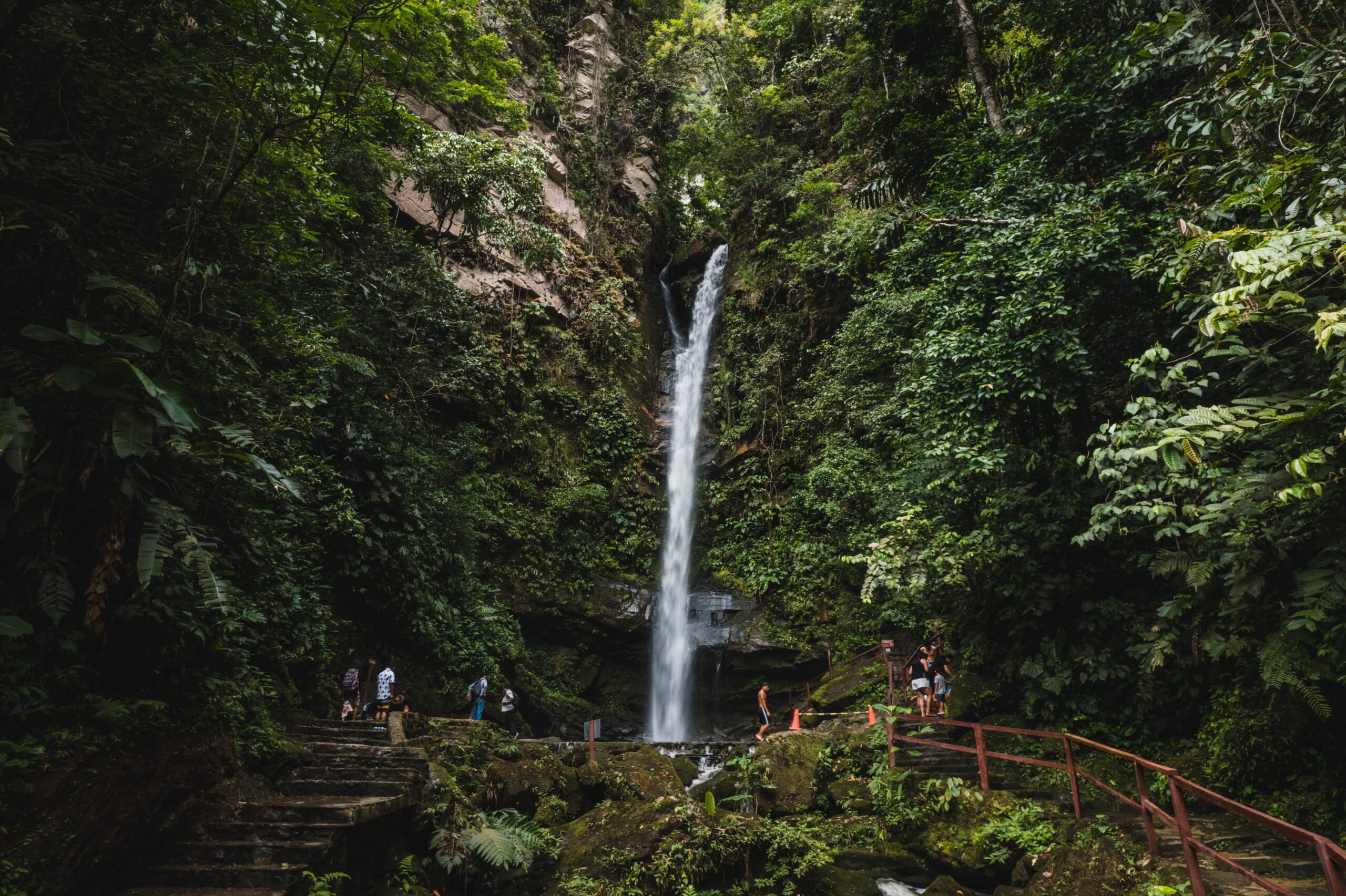 A beautiful waterfall cascades through lush jungle greenery in Tarapoto, Peru, attracting visitors and hikers.